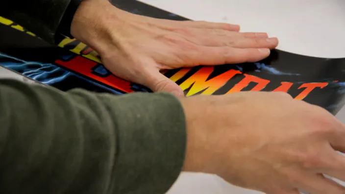 An arcade marquee sticker is placed on a piece of acrylic.