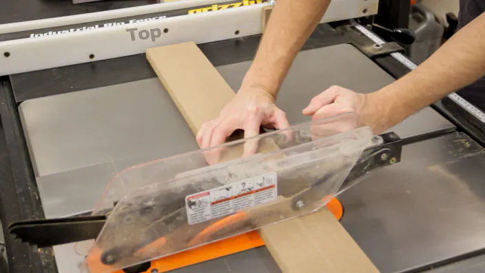 A piece of MDF is crosscut on a table saw.