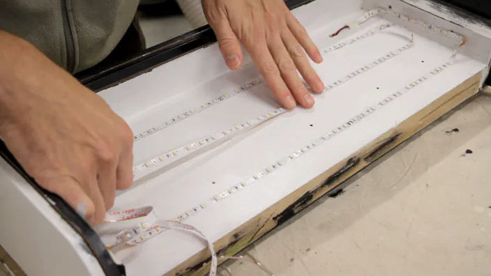A LED light strip is glued to the inside of the lightbox.