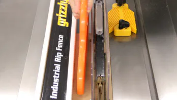 A table saw is used to rip a piece of MDF.