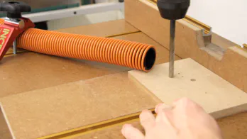 A drill press table and shop-vac hose.