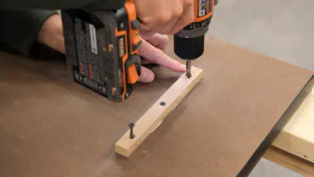 A short cleat is screwed into the bottom of the table.