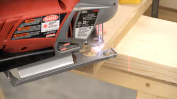 A jigsaw is used to cut a curve on the top surface.