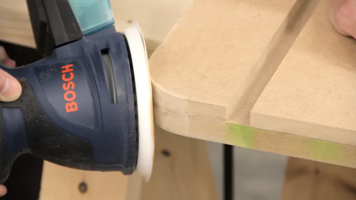 A random orbit sander is used to smooth the cut corner.