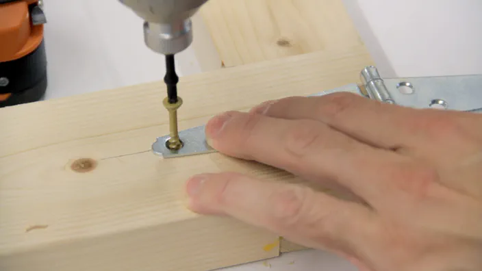 Screws are inserted into a strap hinge.