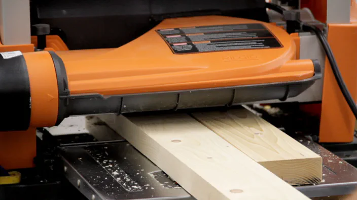A power planer is used to surface a 2x4.