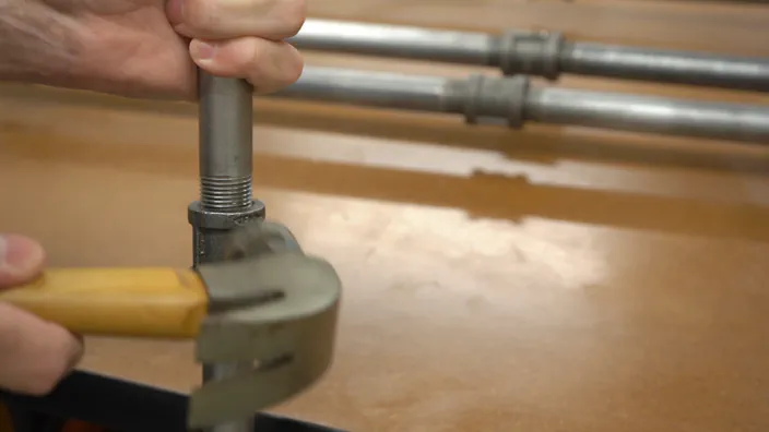 A hammer is used to loosen a steel pipe connection.