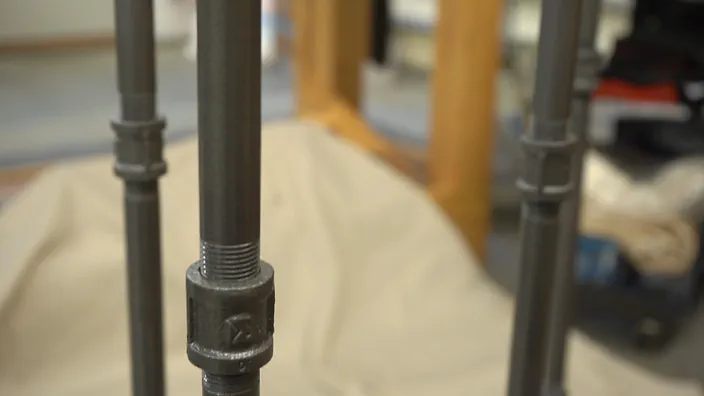 Paint is applied to steel pipe legs.