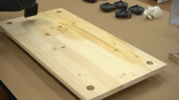 Pre-stain conditioner is applied to shelving.