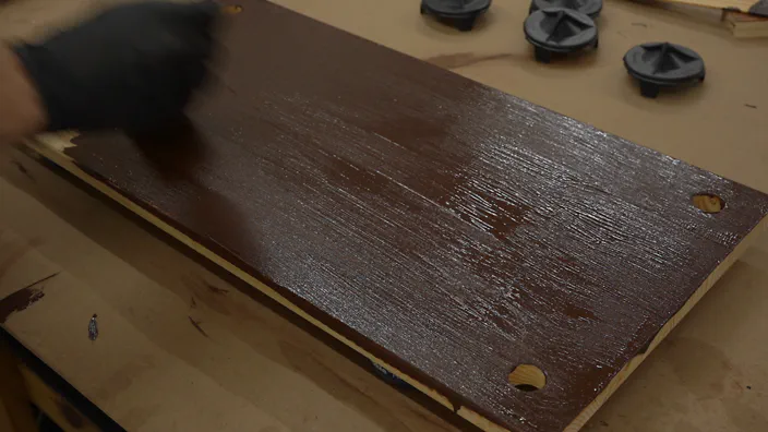 Gel stain is applied to wooden shelving.