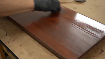 Applying a finish to wooden shelving.