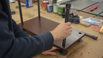 Pipe legs are assembled with wooden shelving.