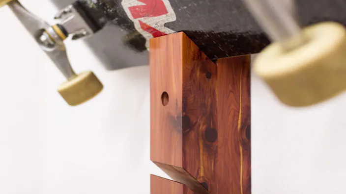 A helmet hanging from a cedar skateboard rack.