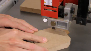 A band saw is used to cut a bevel on the rack side.