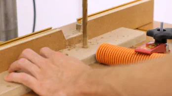 A drill press is used to drill large holes in the top of the rack.