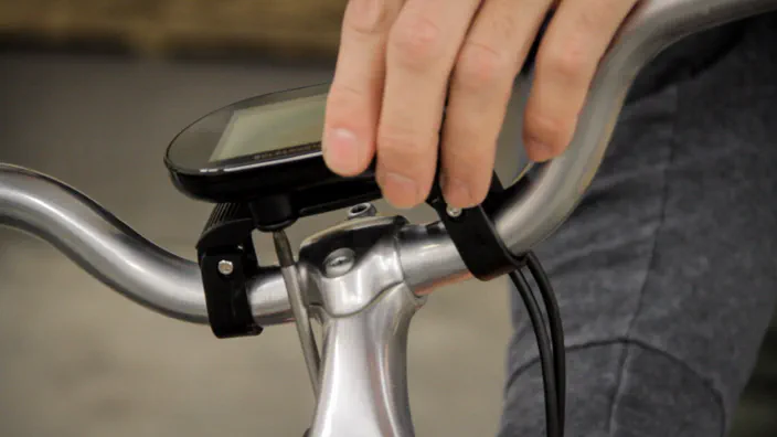 An electric bicycle LCD display is mounted to the handlebars.