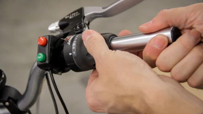 Electric bicycle controls are attached to the left handlebar.