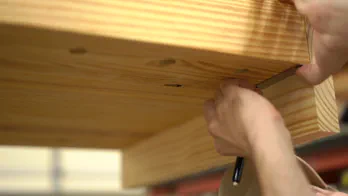 A mark is made on the bottom of the bench top.